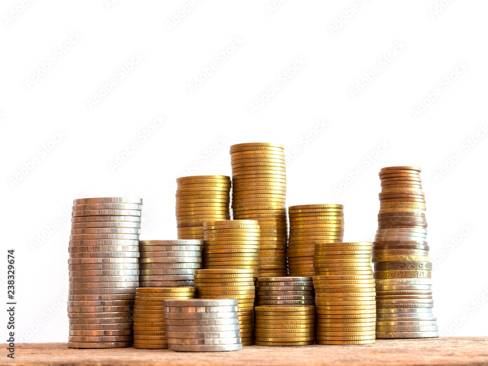 Coins stack on wooden table and white background, Invest your money to get in come,growing business and future concept Coins stack on wooden table and white background, Invest your money to get in come,growing business and future concept
