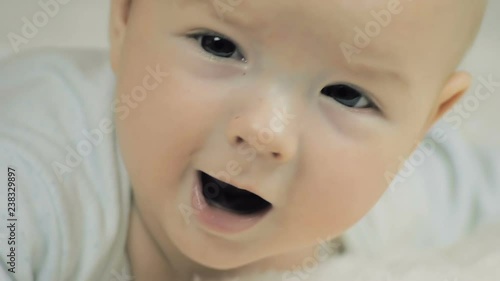Close-up of a six-month-old baby talking and looking at the camera in slow motion.
