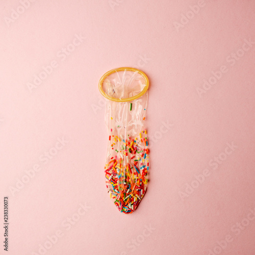 Obraz na płótnie a condom full of nonpareils of many colors on pink background, love saint valentine concept w salonie