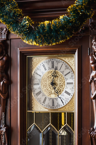 Dial clock is decorated with New Year garland