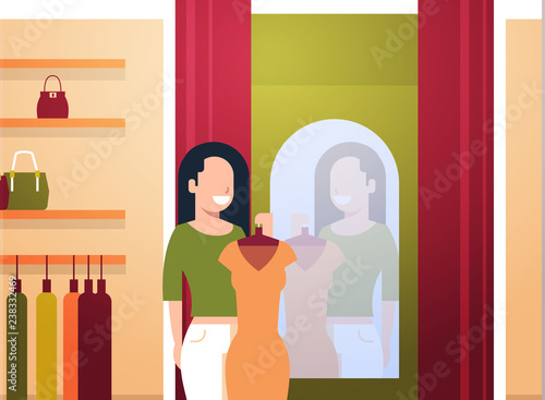 business woman trying on new dress elegant woman looking at mirror fashion shop female clothes market modern shopping mall interior flat horizontal