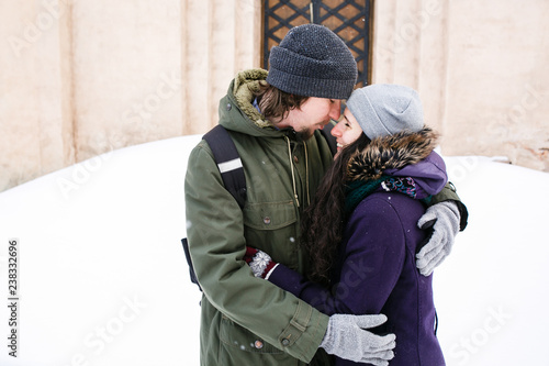 Young couple kissing on the street under the snowfall