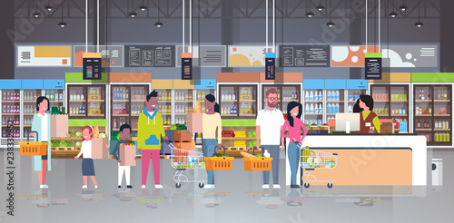 retail woman cashier at checkout supermarket mix race customers holding basket with food standing line queue shopping concept grocery market interior flat horizontal