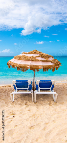 Two chairs and umbrella on the tropical beach of Mullet Bay  Sint Maarten  Caribbean. 