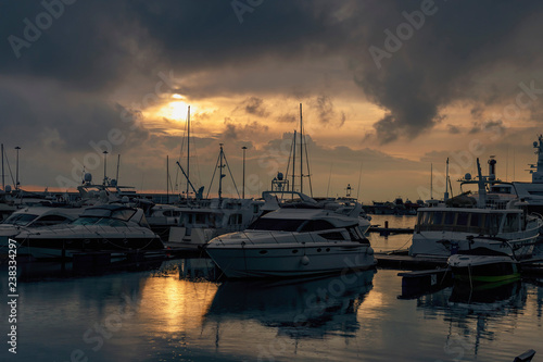 boats and sailboats in a quiet harbor on the background of a beautiful sunset sky