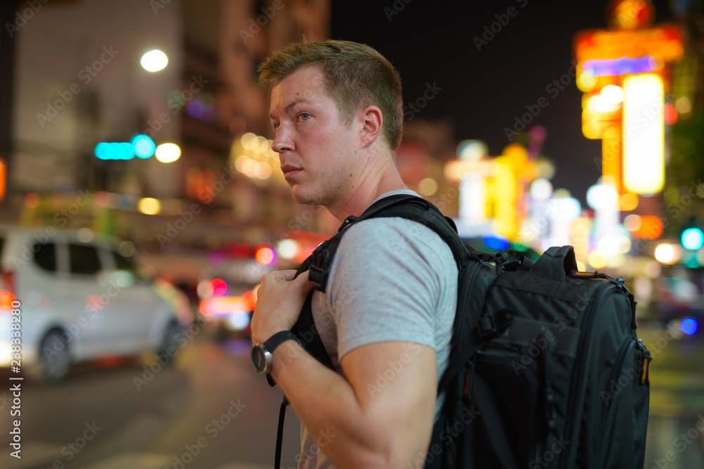 Young tourist man backpacker thinking in the streets of Chinatown at night Young tourist man backpacker thinking in the streets of Chinatown at night