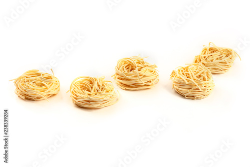 A photo of udon noodles in the shape of egg nests on a white background with copy space