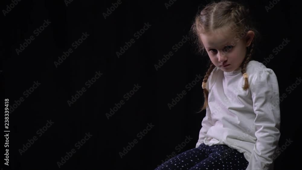 Lonely and sad little child got lost, on the black background Lonely and sad little child got lost, on the black background