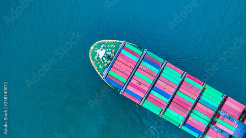 Aerial view cargo container ship carrying container for import and export, business logistic and transportation by ship in open sea. © Kalyakan