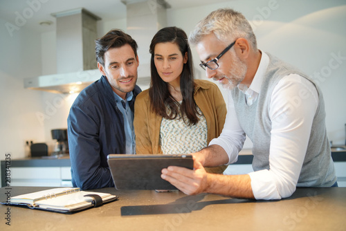  Kitchen salesman going through ideas with potential buyer couple