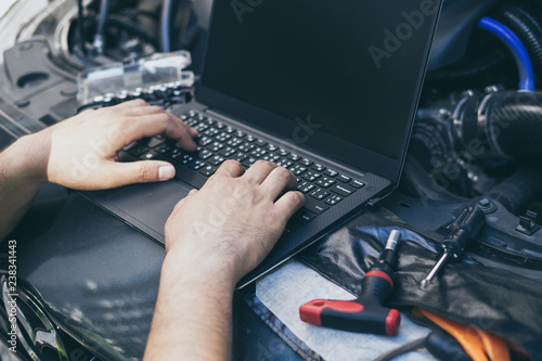 Canvas Print Close up engineer  mechanic using electrnoic diagnostic equipment to tune a car