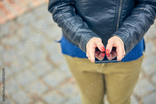 Woman using modern smartphone on the street. photo