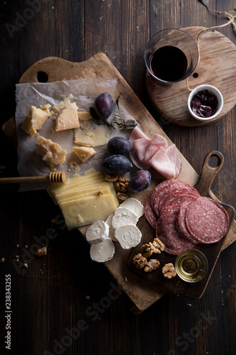 Cheese and meat board, snacks for wine with walnuts and honey