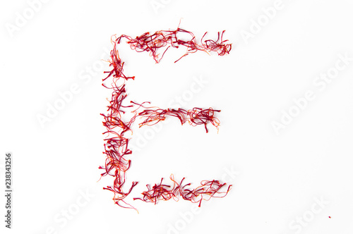 Alphabet made with saffron red gold of sardinia isolated on white clean background