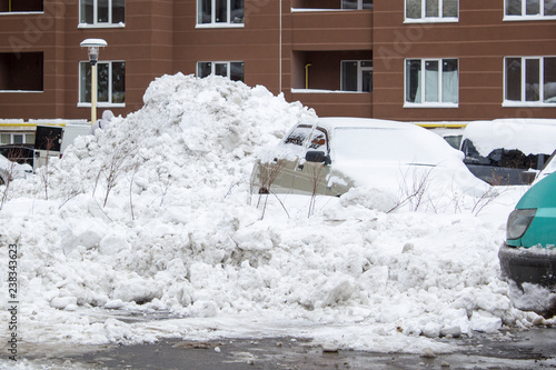 Bild auf Leinwand Parked car under snow cover. Winter parking background