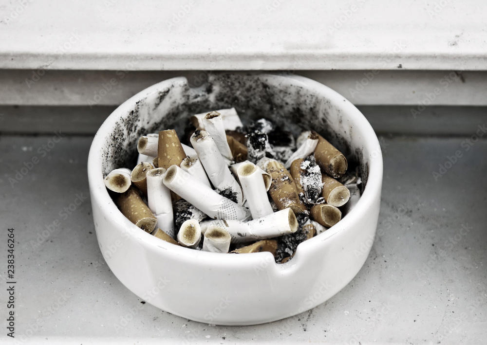 Heap of cigarette butts in a ashtray.