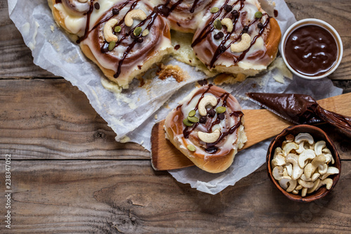 sinabon with cream cheese and cream, chocolate and cashew nuts on wooden background photo