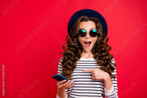 Portrait of nice funky childish attractive positive wavy-haired lady in striped pullover eyeglasses eyewear sunhat showing sms opened mouth isolated over bright vivid shine red background