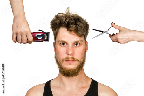 hand with clipper and hand with scissors cut overgrown unshaven guy with a beard on a white isolated background