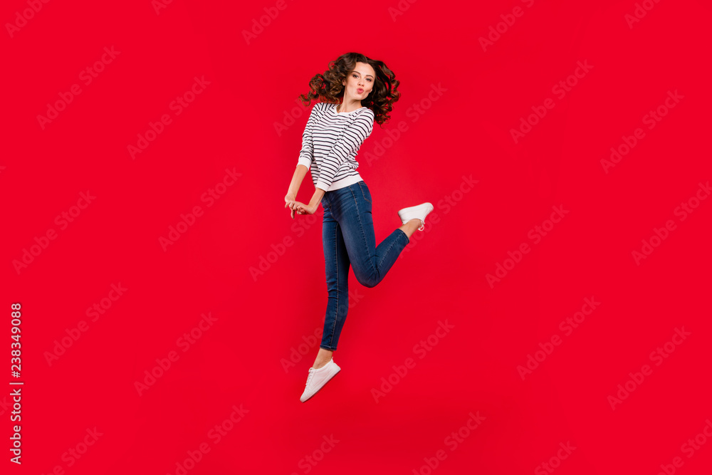 Full length size body photo of jumping high beautiful pretty charming she her girl raised leg fooling send kisses arms together wearing white casual sweater on red vivid bright background