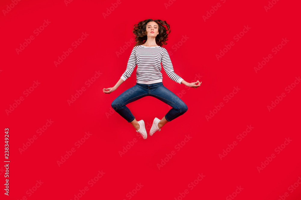Full length size body photo of fly high pretty charming she her girl getting yoga energy in lotus pose wearing striped white casual sweater on red vivid bright background Full length size body photo of fly high pretty charming she her girl getting yoga energy in lotus pose wearing striped white casual sweater on red vivid bright background