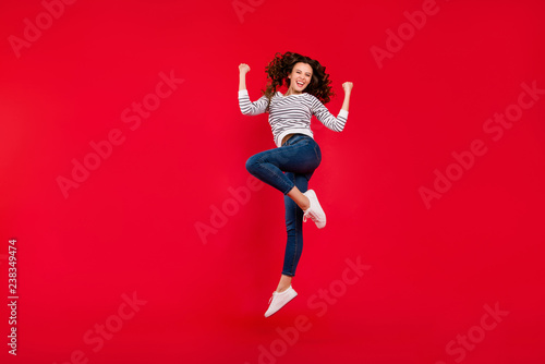 Full length size body photo of fly high attractive beautiful her girl jumping of gladness about score goal in football soccer wearing striped white casual sweater on red bright background