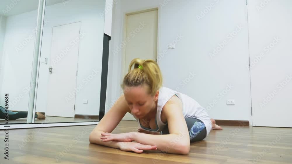 woman stretching near mirror at her apartment. The concept of a healthy lifestyle, not a professional sport. woman stretching near mirror at her apartment. The concept of a healthy lifestyle, not a professional sport.