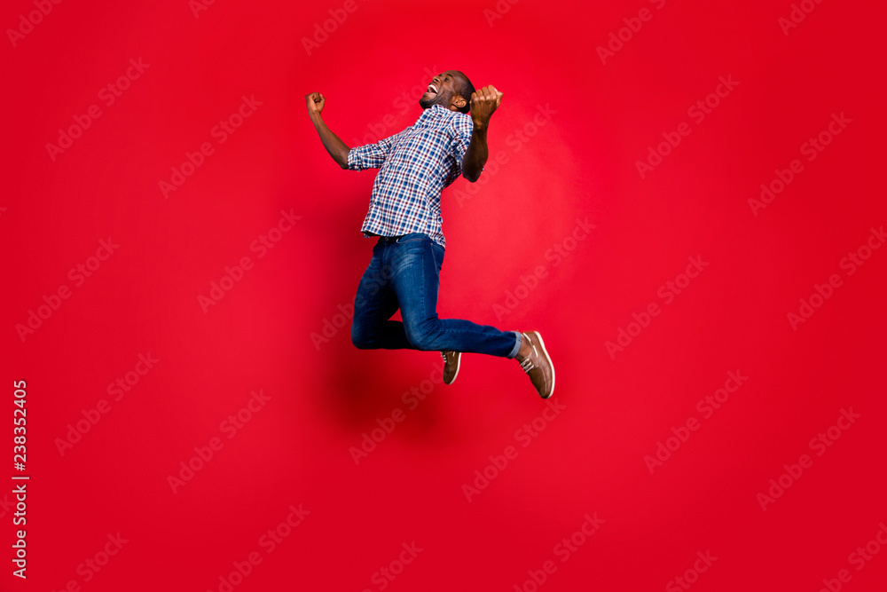 Full length body size portrait of nice funny glad handsome cheerful positive trendy guy wearing checkered shirt showing winning gesture cool party in air isolated on bright vivid shine red background Full length body size portrait of nice funny glad handsome cheerful positive trendy guy wearing checkered shirt showing winning gesture cool party in air isolated on bright vivid shine red background