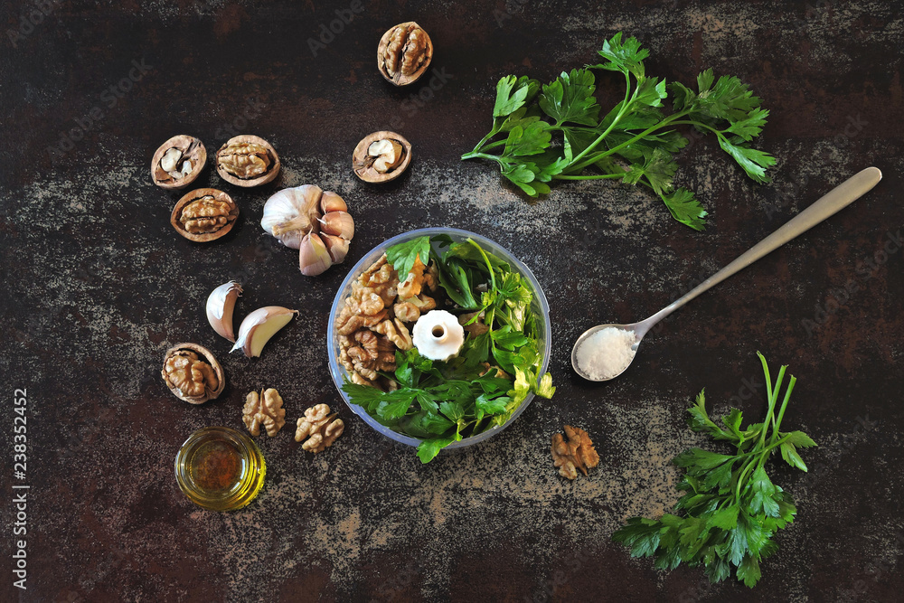 Cooking parsley pesto with walnuts. Ingredients for pesto in a blender cup. Cooking parsley pesto with walnuts. Ingredients for pesto in a blender cup.