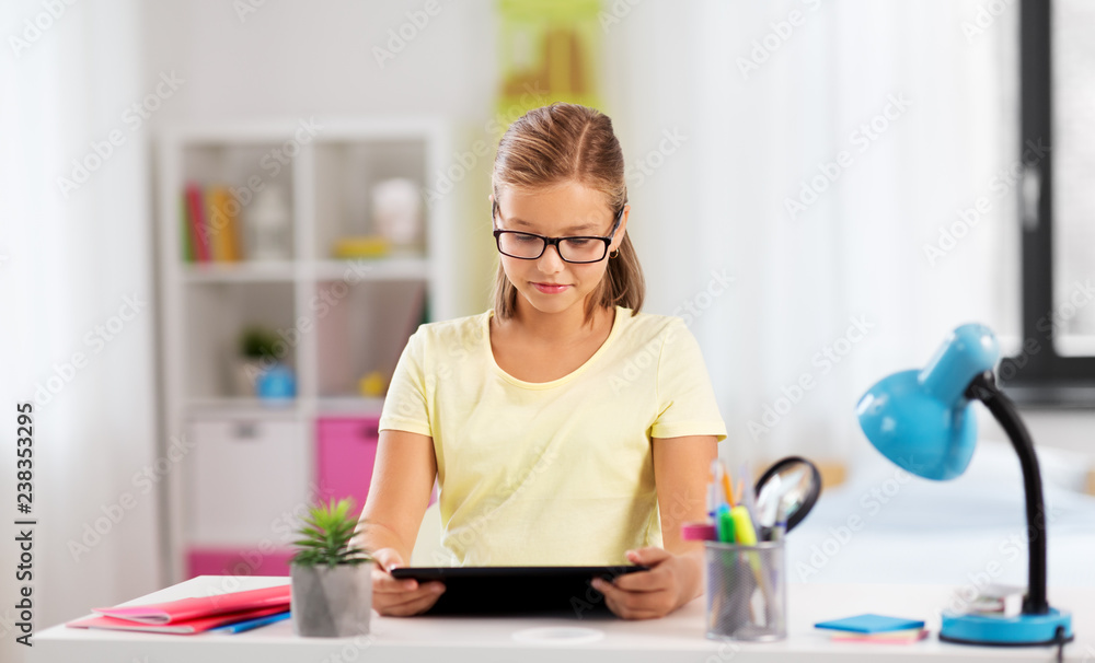 education, technology and learning concept - student girl with tablet computer doing homework at home education, technology and learning concept - student girl with tablet computer doing homework at home