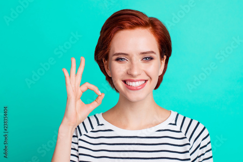 Close-up portrait of her she nice charming attractive cheerful cheery red-haired lady wearing striped pullover showing ok-sign isolated over bright vivid shine green turquoise background