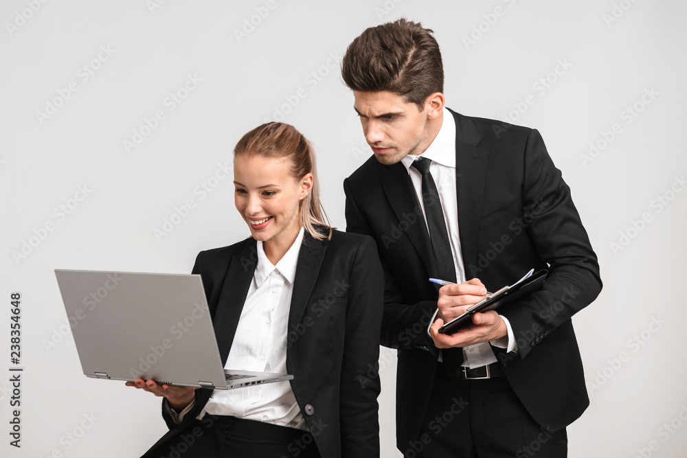 Smiling business couple wearing suits standing Smiling business couple wearing suits standing