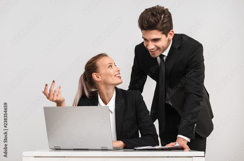 Smiling business couple wearing suits standing Smiling business couple wearing suits standing
