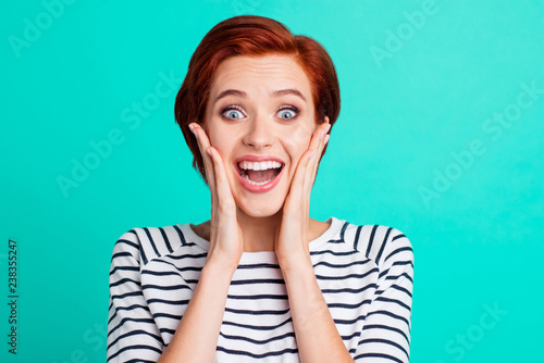 Close-up portrait of nice attractive adorable lovely pretty excited red-haired lady in striped pullover palms on cheeks isolated over bright vivid shine green turquoise background