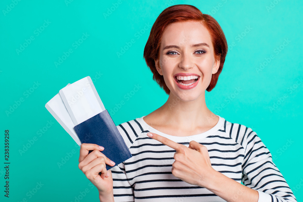 Closeup photo portrait of cheerful crazy excited laughing ecstatic rejoicing pretty honest with short hairstyle she lady student demonstrating two train tickets in hand isolated turquoise background Closeup photo portrait of cheerful crazy excited laughing ecstatic rejoicing pretty honest with short hairstyle she lady student demonstrating two train tickets in hand isolated turquoise background