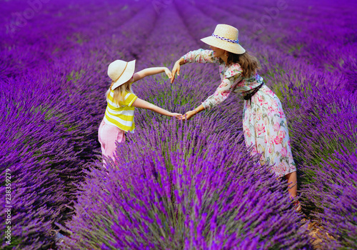 Fotografie mother and child against lavender field making heart with hands