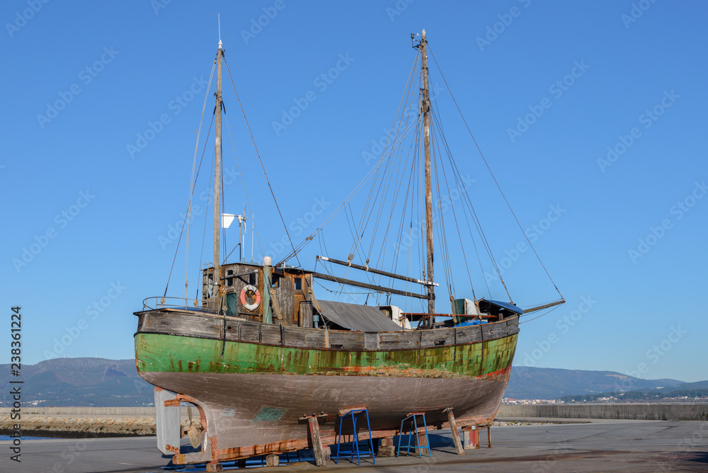 old wooden fishing boat on the shore to dry