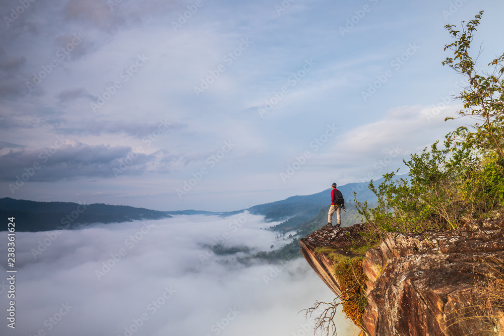 The man are looking to  the  sea of mist on high mountain in Nakornchoom, Phitsanulok province, Thailand.
