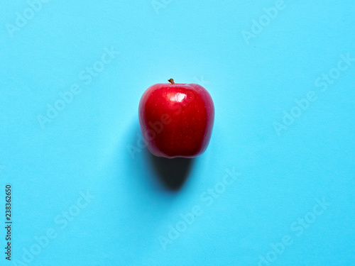 Above view of a red apple isolated in a blue background in studio top view