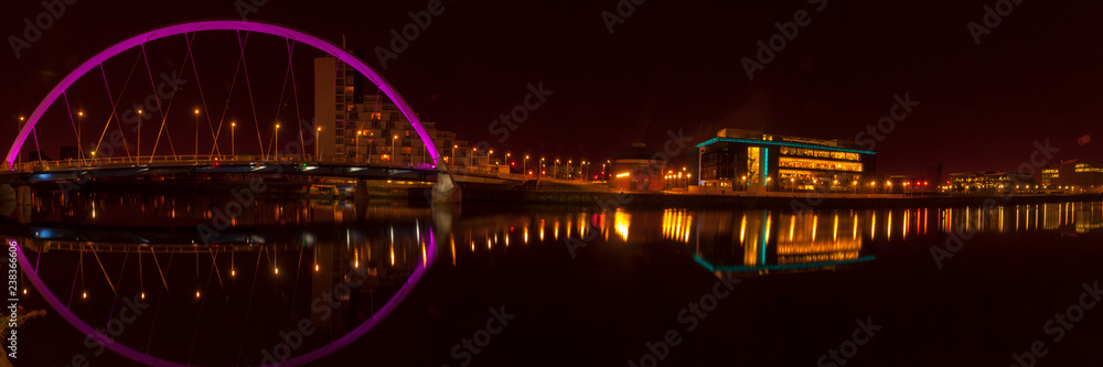 Obraz premium Night time shot of the Glasgow Arc or Finnieston Bridge with the Pacific Quay and Clyde Auditorium in the background, Glasgow, Scotland