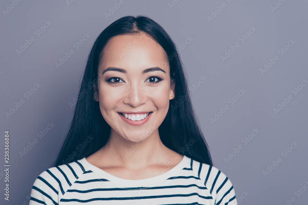 Close up photo portrait of gladly smiling pretty she her girl looking sincerely with brown eyes white teeth wearing white striped pullover isolated on grey background Close up photo portrait of gladly smiling pretty she her girl looking sincerely with brown eyes white teeth wearing white striped pullover isolated on grey background
