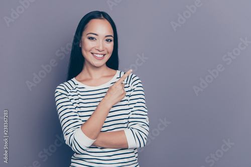 Close up portrait of attractive amazing brown-haired she her girl holding hand finger up to empty space showing new clothes collection wearing white pullover isolated on grey background