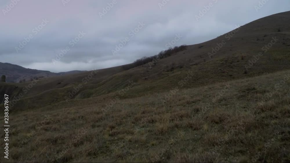 flying drone over a hillside against a cloudy sky flying drone over a hillside against a cloudy sky
