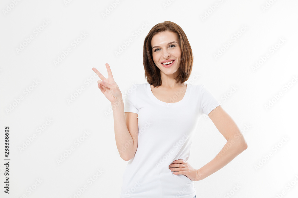 Happy young caucasian girl showing victory sign isolated on white background. Copy space. Template and blank summer t shirt. - obrazy, fototapety, plakaty 