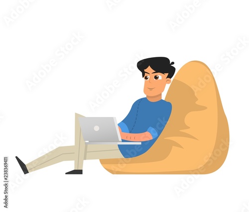 Young Man Freelancer Working with Laptop sitting in Armchair