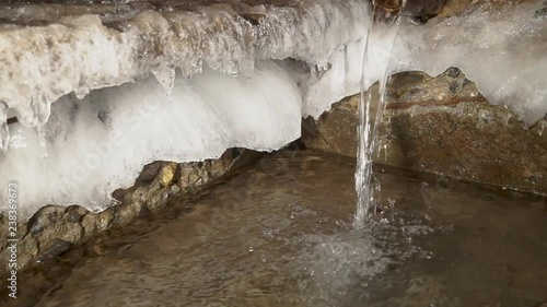 Water is like an endless engine. The source of artesian water flows into the winter frost in a strong winter.