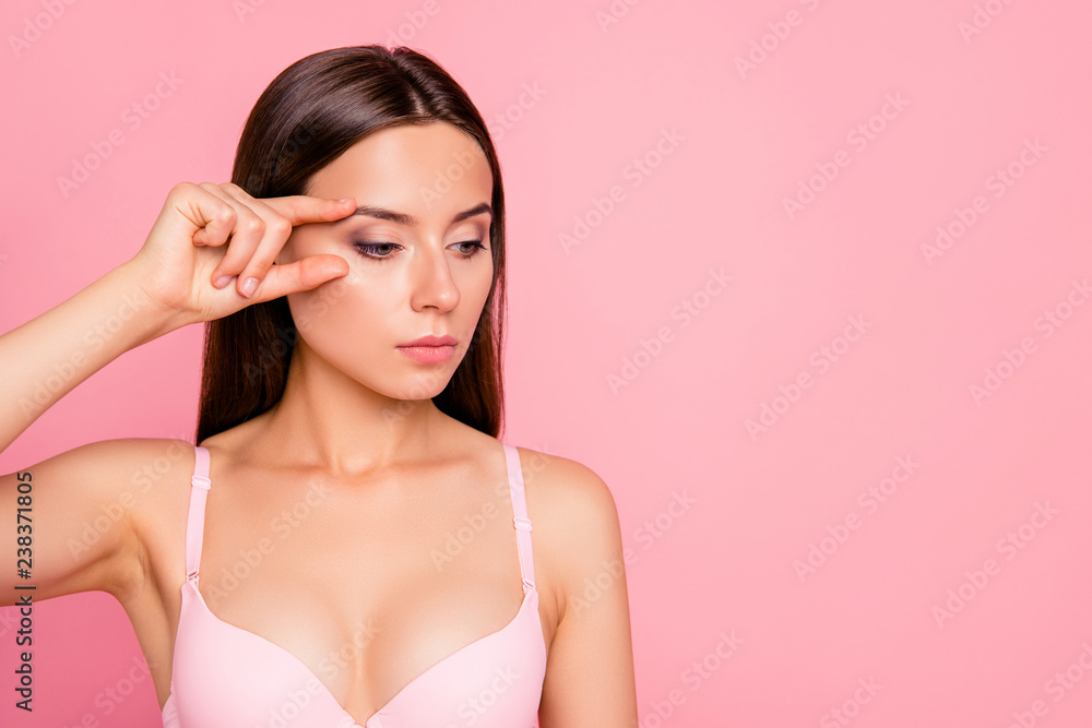 Close up portrait of serious brunette gorgeous problem facial skin her she feminine girl ready to make plastic rejuvenation of eyes wearing pale pink bra isolated on rose background Close up portrait of serious brunette gorgeous problem facial skin her she feminine girl ready to make plastic rejuvenation of eyes wearing pale pink bra isolated on rose background