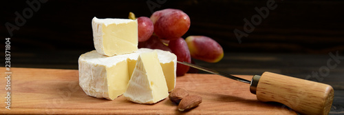 Cheese and grapes on a dark background photo