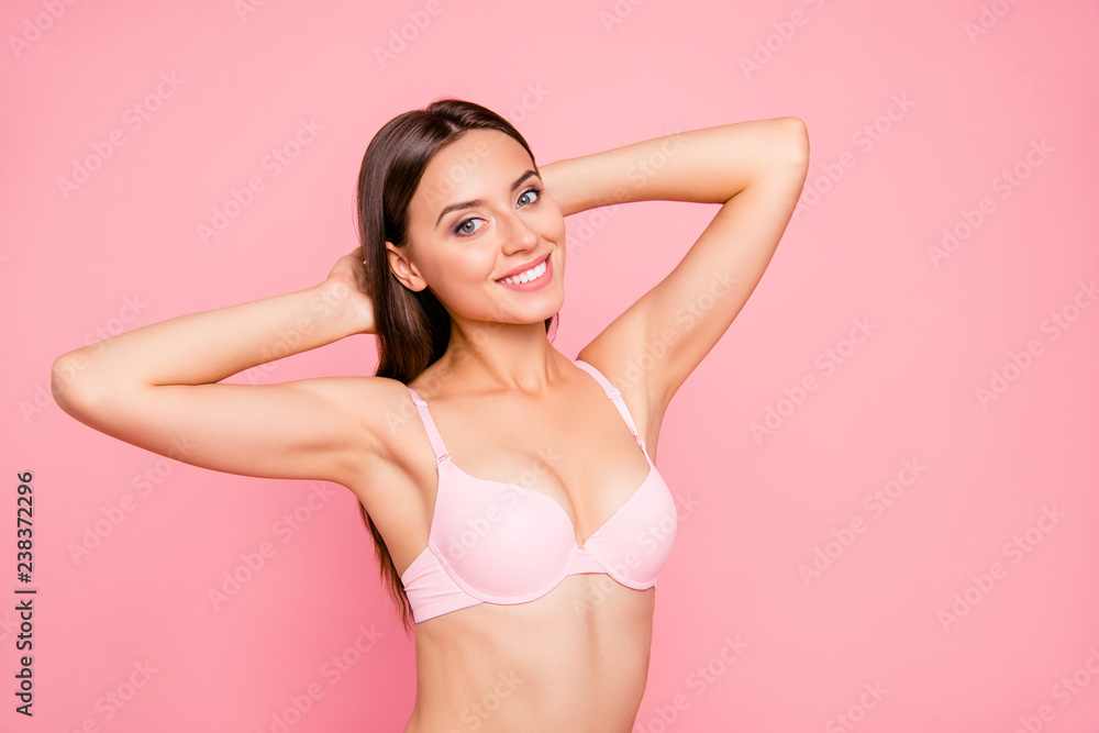Close up portrait of tender cute gentle gorgeous skinny her she girl  satisfied after using balm for jugs raise in bra hands behind head isolated  on pink background Stock Photo