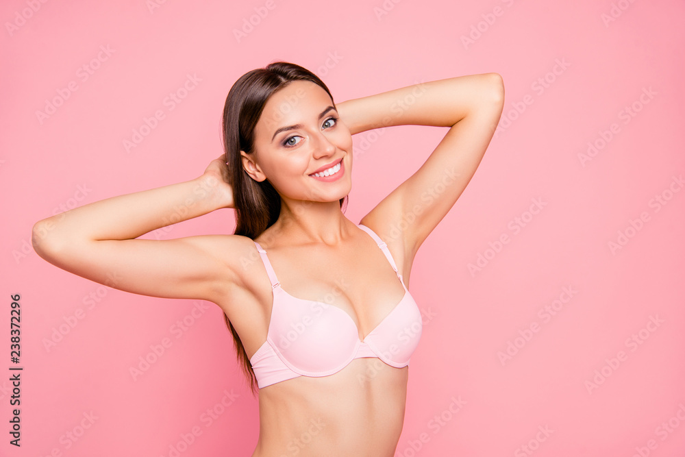 Naklejka premium Close up portrait of tender cute gentle gorgeous skinny her she girl satisfied after using balm for jugs raise in bra hands behind head isolated on pink background